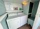Functional laundry room featuring a washer, dryer, storage shelf, and an adjacent storage bench at 3504 Estrada St, Sarasota, FL 34239