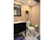 A cozy bathroom with a black vanity and toilet with neutral walls and floors at 3630 White Pine Ct # 138, Sarasota, FL 34238