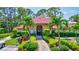 A clubhouse with a red tile roof, a beautiful entrance and surrounded by landscaped grounds at 3630 White Pine Ct # 138, Sarasota, FL 34238