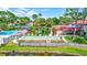 Scenic view of community shuffleboard court, pool, and lush landscaping promoting a relaxed and social atmosphere at 3630 White Pine Ct # 138, Sarasota, FL 34238