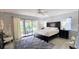 Spacious main bedroom with a large bed, ceiling fan, and access to the lanai at 3630 White Pine Ct # 138, Sarasota, FL 34238