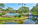 View of the pond with bridge and the community pool surrounded by lush landscaping at 3630 White Pine Ct # 138, Sarasota, FL 34238