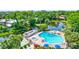 Overhead view of a community pool, hot tub, and pond surrounded by trees at 3630 White Pine Ct # 138, Sarasota, FL 34238
