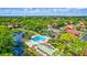 Aerial view of community pool, tennis courts, shuffleboard, pond, and lush landscaping at 3630 White Pine Ct # 138, Sarasota, FL 34238