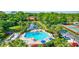 View of community pool, hot tub, pond, tennis courts, and shuffleboard surrounded by lush landscaping at 3630 White Pine Ct # 138, Sarasota, FL 34238