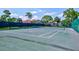 A well-maintained tennis court with neatly painted lines, surrounded by lush greenery, offers an active lifestyle at 3630 White Pine Ct # 138, Sarasota, FL 34238