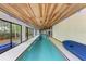 Indoor pool with wood ceiling and multiple sliding glass doors at 3977 Roberts Point Rd, Sarasota, FL 34242