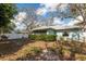 Large partially fenced backyard with mature trees and home exterior at 4614 Breezy Pines Blvd, Sarasota, FL 34232