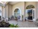 Cozy front porch with arched windows, tiled flooring, and seating area at 4705 Sweetmeadow Cir, Sarasota, FL 34238