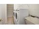 Bright laundry area features a modern washer and dryer along with shelving for optimal organization at 4705 Sweetmeadow Cir, Sarasota, FL 34238