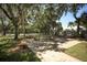 Charming outdoor seating area with picnic tables under mature trees with a playground nearby at 4705 Sweetmeadow Cir, Sarasota, FL 34238