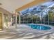 The pristine pool area is enclosed and allows for sunlight and views of the lush tropical backyard at 4705 Sweetmeadow Cir, Sarasota, FL 34238
