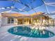 Sparkling swimming pool with clear blue water, surrounded by ample patio space in a screened enclosure at 4705 Sweetmeadow Cir, Sarasota, FL 34238