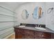 Bathroom with floating shelves, double vanity with granite countertop, and dual mirrors at 5002 Bunyan St, Sarasota, FL 34232