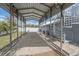 Long carport featuring fans, lights, spiral stairs and a gravel driveway at 5002 Bunyan St, Sarasota, FL 34232