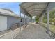 Large carport with corrugated roof and gravel flooring offering ample shaded parking at 5002 Bunyan St, Sarasota, FL 34232