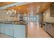 Open-concept kitchen featuring stainless steel appliances, an island, and wood plank ceiling at 5002 Bunyan St, Sarasota, FL 34232