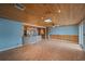 Open-concept living space with a view of the kitchen featuring tile floors and wood plank ceilings at 5002 Bunyan St, Sarasota, FL 34232