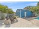 Blue outbuilding adjacent to a brick patio with lush landscaping at 5002 Bunyan St, Sarasota, FL 34232