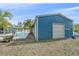 View of large blue outbuilding near a private pool surrounded by lush tropical landscaping at 5002 Bunyan St, Sarasota, FL 34232