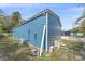 Side view of the exterior of blue outbuilding shows utilities at 5002 Bunyan St, Sarasota, FL 34232