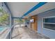 Screened-in patio featuring brick pavers, a ceiling fan, and a wall-mounted television for outdoor entertainment at 5002 Bunyan St, Sarasota, FL 34232