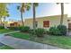 Condo exterior showcasing lush greenery, palm trees, and distinctive red window and balcony accents at 503 Spring Lakes Blvd # 503, Bradenton, FL 34210