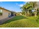 Lush backyard featuring a well-maintained lawn, mature trees, and a brick-paved patio area with blue chairs at 5814 117Th E Ter, Parrish, FL 34219