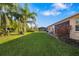 Spacious backyard featuring a lush lawn, tropical landscaping, and screened-in porch, perfect for outdoor enjoyment at 5814 117Th E Ter, Parrish, FL 34219
