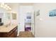 Bathroom featuring a single vanity, mirror, and doorway leading to a bedroom with calming color scheme at 5814 117Th E Ter, Parrish, FL 34219
