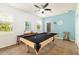 Bright game room with a billiards table, fan, and natural light from windows overlooking the lush landscaping at 5814 117Th E Ter, Parrish, FL 34219