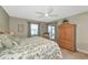 Bright bedroom with floral bedding, ceiling fan, sliding glass doors, and a view of the screened lanai at 617 Estuary Dr # 617, Bradenton, FL 34209