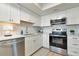 Kitchen boasts stainless appliances, white cabinets, subway tile, light floors, and plenty of storage at 617 Estuary Dr # 617, Bradenton, FL 34209