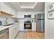Modern kitchen featuring stainless appliances, white cabinets, subway tile, and light wood-look flooring at 617 Estuary Dr # 617, Bradenton, FL 34209