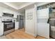 Kitchen with laundry area features stainless appliances, white cabinets, subway tile, and light wood-look flooring at 617 Estuary Dr # 617, Bradenton, FL 34209
