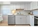 Bright kitchen features white cabinets, white subway tile backsplash, quartz countertops, and stainless appliances at 617 Estuary Dr # 617, Bradenton, FL 34209