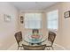 Charming dining area featuring a glass-top table and wicker chairs, bathed in natural light from surrounding windows at 6326 Grand Oak Cir # 203, Bradenton, FL 34203