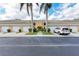 Building with garages, lush bushes and trees, and an inviting walkway at 6326 Grand Oak Cir # 203, Bradenton, FL 34203
