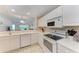 Clean kitchen with white cabinetry, appliances, and white countertops at 6326 Grand Oak Cir # 203, Bradenton, FL 34203
