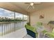 Screened patio overlooking serene lake is furnished with a glass table and four cushioned chairs at 6326 Grand Oak Cir # 203, Bradenton, FL 34203