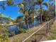 The fenced in yard overlooks a canal surrounded by palm trees and native vegetation at 6704 35Th W Ave, Bradenton, FL 34209