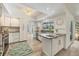 Open kitchen with tiled floors, white cabinets, and island with sink at 7115 11Th W Ave, Bradenton, FL 34209