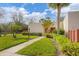 Single-story villa with a lush green lawn, palm trees, and a walkway leading to the front door at 801 Spring Lakes Blvd # 801, Bradenton, FL 34210