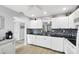Bright kitchen with white cabinets, black countertops, and eye-catching mosaic backsplash at 801 Spring Lakes Blvd # 801, Bradenton, FL 34210