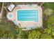 Aerial shot of a pool and hot tub, with lounge chairs, umbrellas, and mature landscaping at 801 Spring Lakes Blvd # 801, Bradenton, FL 34210