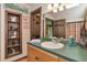 Bathroom with oak cabinets, green countertop, and decorative driftwood sculpture at 805 Mcarthur Ave, Sarasota, FL 34243