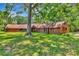 A single story home with mature landscaping and expansive front yard and mature trees at 805 Mcarthur Ave, Sarasota, FL 34243
