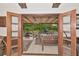 A view from the doorway to the beautiful screened porch with beamed ceiling and greenery at 805 Mcarthur Ave, Sarasota, FL 34243