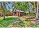 Outdoor shed with a basketball hoop, sitting amongst the lush yard and mature trees at 805 Mcarthur Ave, Sarasota, FL 34243