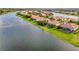 An aerial view of a waterfront community showcasing beautiful homes with screened-in pools and tile roofs along a scenic lake at 8290 Barton Farms Blvd, Sarasota, FL 34240